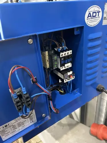 Replacement electrical contactor and overload fitted inside the control panel of a Nilfisk DTE wall-mounted pressure washer.